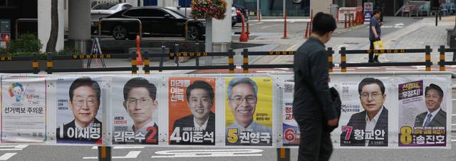 21대 대선을 15일 앞둔 19일 서울 중구 퇴계로에서 시민들이 선거 벽보를 보며 걸어가고 있다. 뉴시스