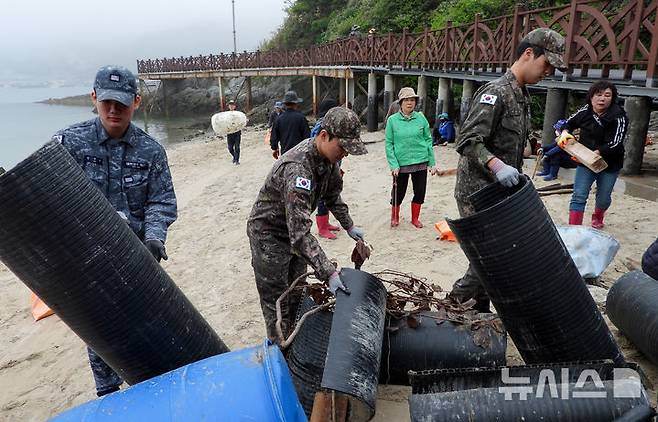 [평택=뉴시스] 해군2함대 282감시대 장병들이 주민들과 어청도 해안가 일대에서 해양정화활동으로 해양쓰레기를 수거하고 있다.(사진=해군2함대 제곹) 2025.05.22.photo@newsis.com