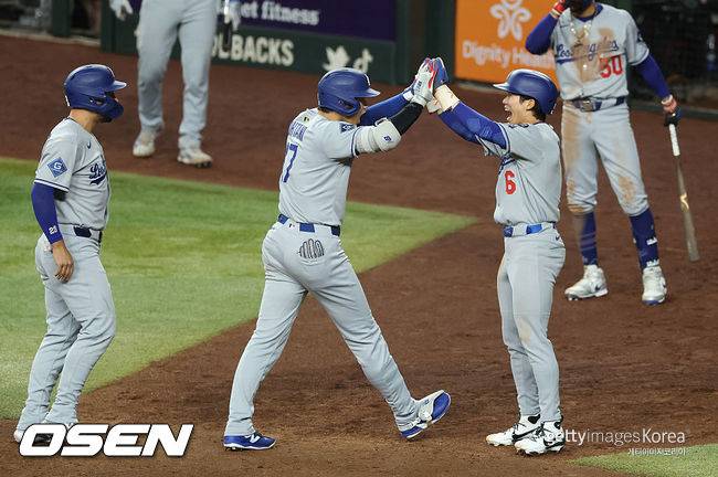 [사진] LA 다저스 오타니 쇼헤이(가운데)가 홈런을 친 뒤 김혜성의 환영을 받고 있다. ⓒGettyimages(무단전재 및 재배포 금지)