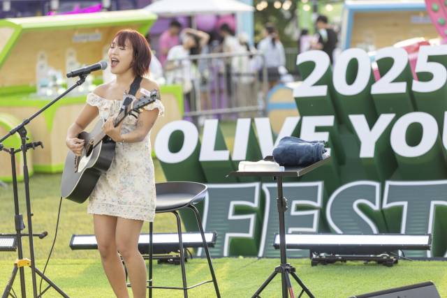 인디 뮤지션 김뜻돌이 22일 ‘올리브영 페스타’에서 야외 버스킹 무대로 마련된 ‘올리브 그린 사운즈 with CJ문화재단’ 무대에 올라 노래를 부르고 있다. 사진 제공=CJ문화재단