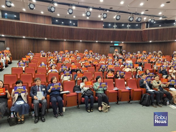 23일 오후 국회 도서관 대강당에서 열린 '발달지연·장애영유아 지원체계구축을 위한 토론회(유보통합 과정에서)'에서 참석자들이 '교육부 장애영유아특수교육지원과 설치', '조기개입 지원체계 조속히 마련'이라고 적힌 피켓을 들고 기념촬영을 하고 있다. ⓒ육아정책연구소