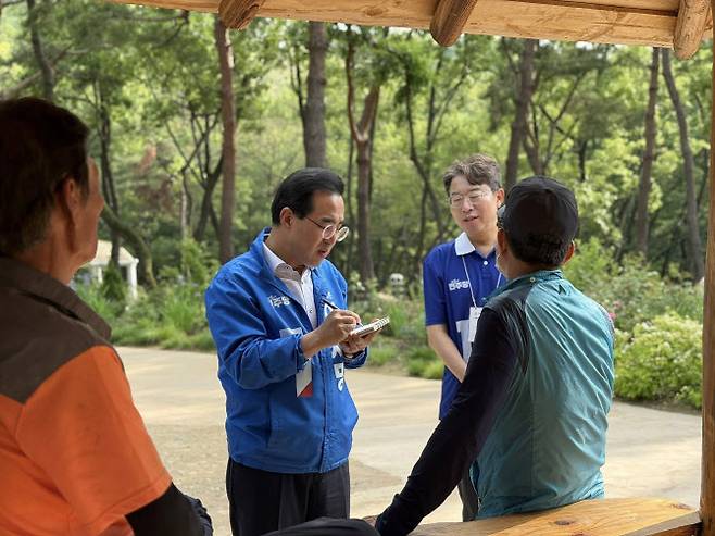박홍근 더불어민주당 의원(골목골목선거대책위 서울위원장 겸 총괄선대본부 직능본부장)이 22일 서울 금천구 오미생태공원에서 유세를 다니며 한 시민이 준 의견을 메모하고 있다. (사진=박홍근의원실)