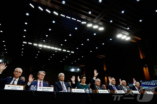 왼쪽부터 △웰스파고 CEO 겸 사장 찰스 W. 샤프 △뱅크오브아메리카 회장 겸 CEO 브라이언 토마스 모이니한△JP모간체이스 회장 겸 CEO 제이미 다이먼 △씨티그룹 CEO 제인 프레이저 △스테이트 스트리트 CEO 로날드 오핸리 △BNY 멜론 CEO 로빈 빈스 △골드만 삭스 CEO 데이비드 솔로몬 △모간스탠리 회장 겸 CEO 제임스 고먼이 2023년 12월 6일 미국 워싱턴 의사당에서 열린 월스트리트 기업들에 대한 미국 상원 은행주택도시문제위원회 청문회에서 손을 들고 있다. 2023.12.6 ⓒ 로이터=뉴스1 ⓒ News1 강민경 기자