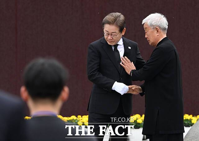 참배를 마친 뒤 배우 명계남과 인사하는 이재명 후보.