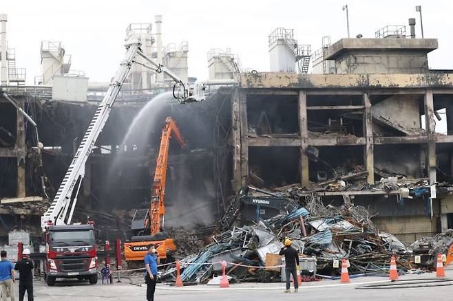 22일 오전 광주 광산구 금호타이어 광주공장에서 수습당국이 중장비를 이용해 불이 난 건물을 해체하고 있다. 연합뉴스