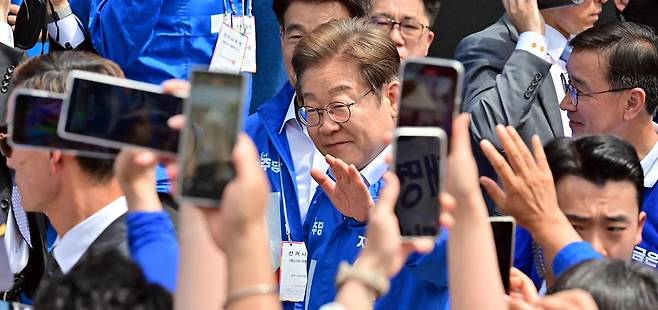 더불어민주당 이재명 대선 후보가 22일 오전 제주 동문시장 앞 탐라문화광장에 들어서자 지지자들이 휴대전화를 들고 사진을 찍고 있다. 이 후보는 이날 제주를 거쳐 경남 양산시로 이동해 집중 유세를 진행했다. 제주=뉴스1