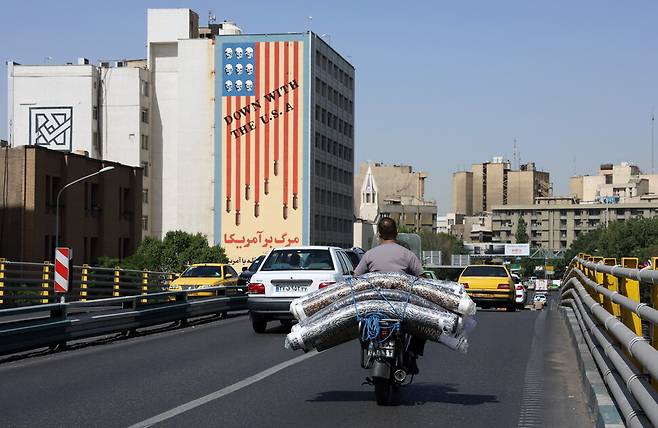 21일(현지시각) 이란 테헤란의 ‘미국 반대’ 벽화 앞을 사람들이 지나가고 있다. 테헤란/EPA 연합뉴스