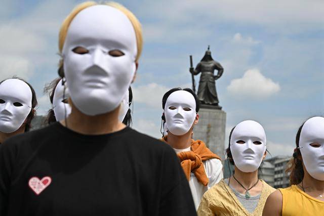 시민들이 22일 서울 광화문 이순신동상 앞에서 흰색 가면을 쓴 채 인간과 동물의 공생을 주장하는 퍼포먼스를 하고 있다. 정다빈 기자 answer@hankookilbo.com