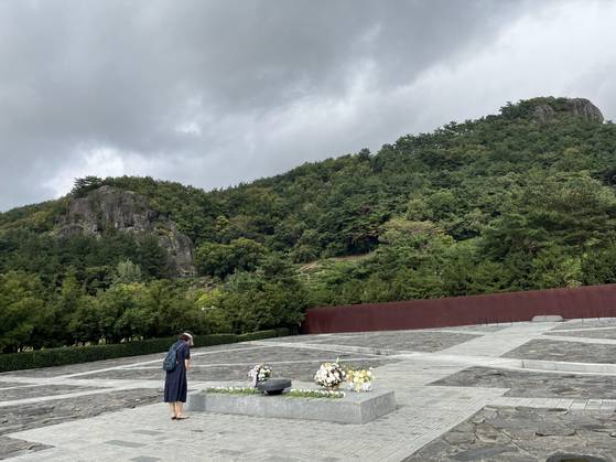 한 시민이 경남 김해시 진영읍 봉하마을 고(故) 노무현 전 대통령 묘역에서 참배하고 있다. 왼쪽 뒤에 보이는 바위가 노 전 대통령이 투신한 부엉이바위다. 고대훈 기자