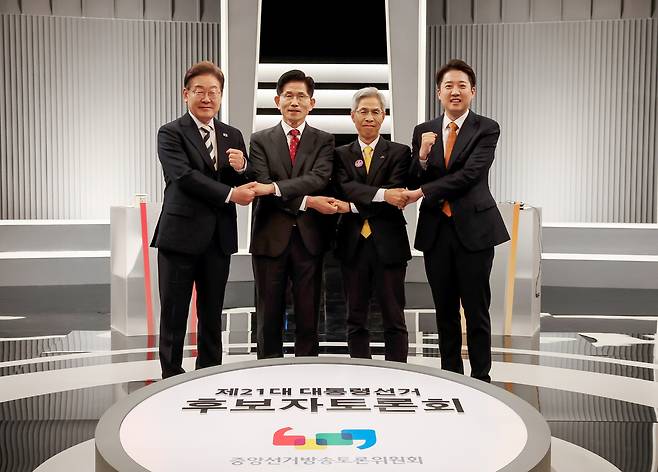 Presidential candidates pose for a photo ahead of their second TV debate at the KBS Studio in Seoul on Friday. From left: Lee Jae-myung of the Democratic Party of Korea, Kim Moon-soo of the People Power Party, Kwon Young-kook of the Democratic Labor Party and Lee Jun-seok of the New Reform Party. (Yonhap)