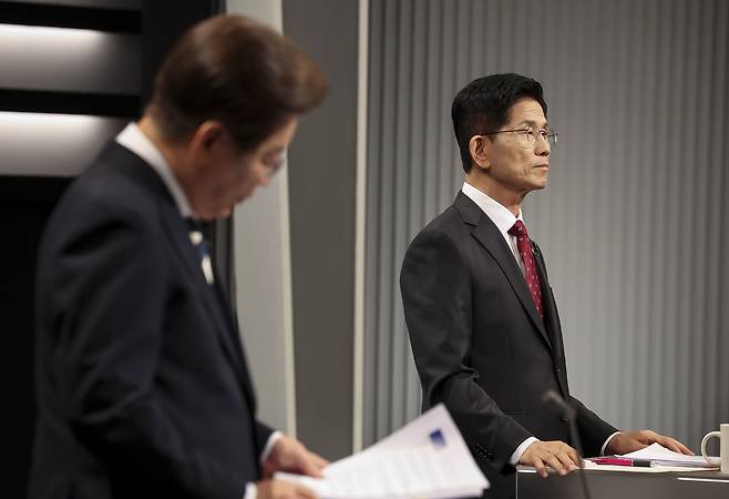 Presidential candidates Lee Jae-myung (left) of the Democratic Party of Korea and Kim Moon-soo of the People Power Party prepare for their second TV debate at the KBS Studio in Seoul on Friday. (Yonhap)