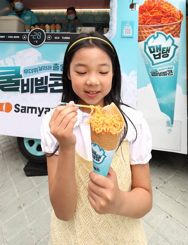 “비빔면 아래에 아이스크림이 있어요!”  삼양식품 ‘출동! 후레시맵’ 캠페인에서 한 어린이가 ‘쿨비빔콘’을 들고 색다른 비주얼에 즐거워하는 모습. 사진제공=삼양식품