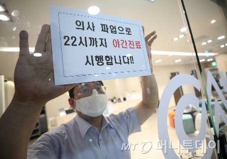 의료계가 총파업 집단 휴진에 돌입한 18일 서울 광진구의 한 한방병원에서 관계자가 야간진료 시행 안내문을 부착하고 있다.  대한한의사협회 소속 전국 한방병원 400여 곳은 이날 의료 공백에 따른 국민 불편을 해소하기 위해 24시간 진료 체제 가동 및 야간 진료에 동참했다./사진=(서울=뉴스1) 오대일 기자