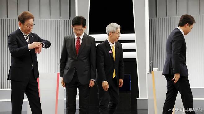 [서울=뉴시스] 국회사진기자단 = 23일 서울 영등포구 KBS본관 스튜디오에서 열린 중앙선거방송토론위원회 주관 제21대 대통령선거 2차 후보자 토론회 시작에 앞서 각 정당 대선후보들이 기념촬영을 마친 뒤 자리로 돌아가고 있다. 왼쪽부터 이재명 더불어민주당, 김문수 국민의힘, 권영국 민주노동당, 이준석 개혁신당 대선후보. 2025.05.23.