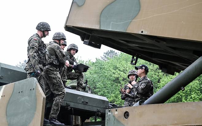 육군은 지난 22일 해외 주요 방산협력국 장병들을 대상으로 K-무기체계의 전술적 운용을 교육하는 '육군 국제과정' 현장 모습을 공개했다.  폴란드군 교육생들이 교관들로부터 천무의 전술적 운용방법에 대한 설명을 듣고 있다. /사진=육군