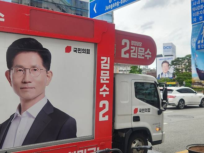 지난 21일 오전 대구광역시 북구 경북대학교 앞에서 중구 동성로에서 이재명 더불어민주당 대선 후보의 선거운동원들이 유세를 펼치고 있다. 같은 날 오후 대구 중구 동성로에서 김문수 국민의힘 대선 후보의 사진이 큼지막하게 걸린 유세차량이 정차해 있다.  이영기 기자
