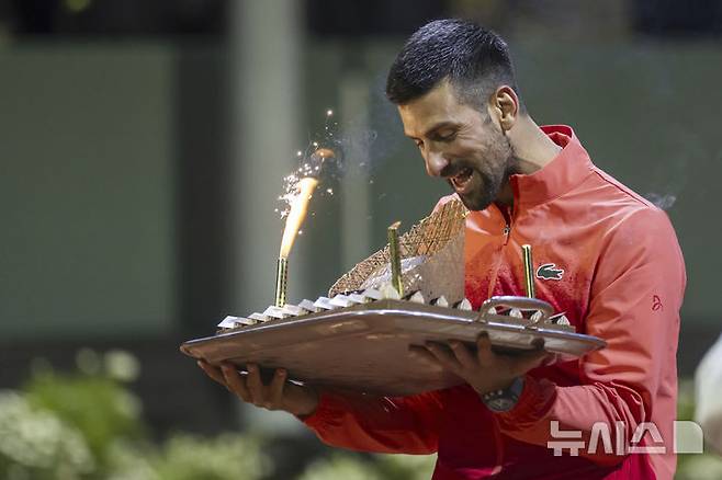 [제네바=AP/뉴시스] 노바크 조코비치(6위·세르비아)가 22일(현지 시간) 스위스 제네바에서 열린 남자프로테니스(ATP) 투어 제네바 오픈(ATP250) 단식 8강전에서 마테오 아르날디(39위·이탈리아)를 꺾은 후 케이크를 들고 생일과 승리를 자축하고 있다. 조코비치가 2-0(6-4 6-4)으로 승리하고 준결승에 올라 캐머런 노리(90위·영국)와 결승 진출을 다툰다. 2025.05.23.