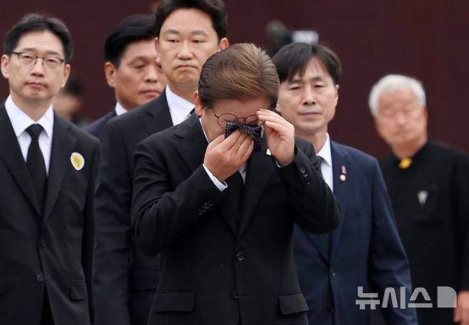 [김해=뉴시스] 조성우 기자 = 이재명 더불어민주당 대선후보가 고 노무현 전 대통령 16주기인 23일 경남 김해시 진영읍 봉하마을을 찾아 노 전 대통령의 묘역을 참배한 이동하며 눈물을 훔치고 있다. 2025.05.23. xconfind@newsis.com