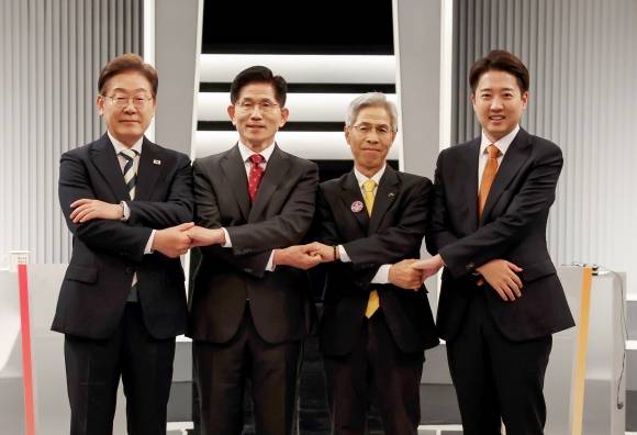 이재명(왼쪽부터)·김문수·권영국·이준석 대선 후보가 23일 서울 영등포구 KBS 스튜디오에서 열린 제21대 대선 2차 토론회 시작에 앞서 손을 맞잡고 함께 사진을 찍고 있다. 2025.5.23 국회사진기자단