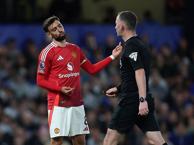 2025년 5월 16일, 영국 런던 스탬퍼드 브리지에서 열린 프리미어리그 첼시와 맨체스터 유나이티드의 경기 중 맨체스터 유나이티드의 브루노 페르난데스가 주심 크리스 카바나와 대화를 나누고 있다.