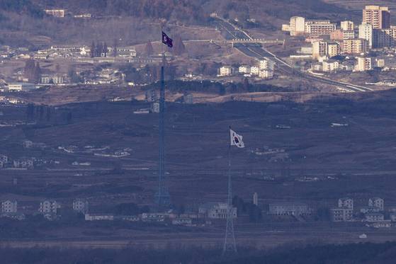 사실상 시장경제 체제 국가인 북한은 여전히 개혁·개방을 하지 않고 있다. 경기도 파주시 접경지역에서 바라본 서부전선 비무장지대(DMZ) 내 남측 대성동 마을 태극기와 북측 기정동 마을 인공기가 먹구름이 만든 그림자 아래에서 마주 보고 있다. [연합뉴스]