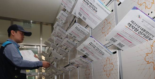 <선거공보물 ‘속’을 보세요>  제21대 대통령선거일을 보름 앞둔 19일 우정사업본부 집배원이 서울 강남구의 한 오피스텔 우편함에 책자형 선거공보물을 넣고 있다. 정효진 기자