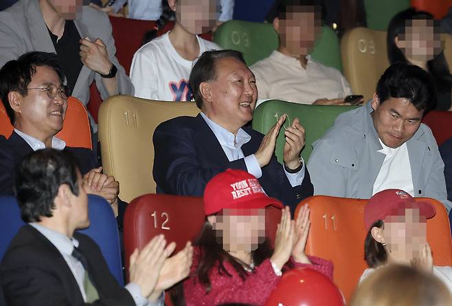<파면 47일 만에 첫 공개 행보> 윤석열 전 대통령이 대선을 13일 앞둔 21일 서울 동대문의 한 영화관에서 부정선거론을 주장하는 다큐멘터리 영화 ‘부정선거, 신의 작품인가’를 관람한 뒤 웃으며 박수를 치고 있다. 두번째 줄 왼쪽부터 영화를 연출한 이영돈 PD, 윤 전 대통령, 전한길 전 한국사 강사. 사진공동취재단