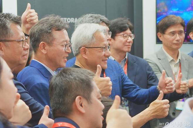 젠슨 황 엔비디아 CEO가 20일 대만에서 열린 '컴퓨텍스 2025' SK하이닉스 전시관을 찾아 SK하이닉스 직원들과 기념사진을 찍고 있다. /사진=김남이 기자