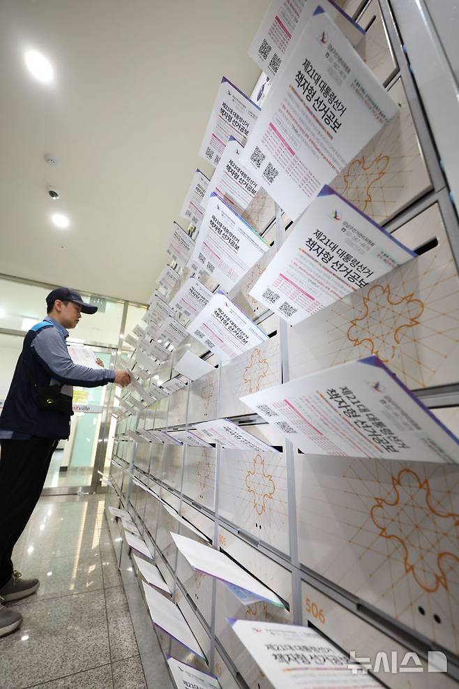 [서울=뉴시스] 조수정 기자 = 우정사업본부 집배원이 21대 대통령선거일을 15일 앞둔 19일 서울 강남구 한 오피스텔에서 책자형 선거공보물을 우편함에 투함하고 있다. 2025.05.19. chocrystal@newsis.com