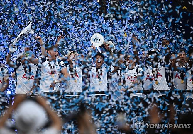 축포 터진 가운데 트로피 들어올린 손흥민 (런던 로이터=연합뉴스) 23일(현지시간) 영국 런던 토트넘 홋스퍼 스타디움 앞에서 열린 유럽축구연맹(UEFA) 유로파리그 우승 기념 퍼레이드 행사에서 주장 손흥민(가운데)이 트로피를 들어 올리고 있다.