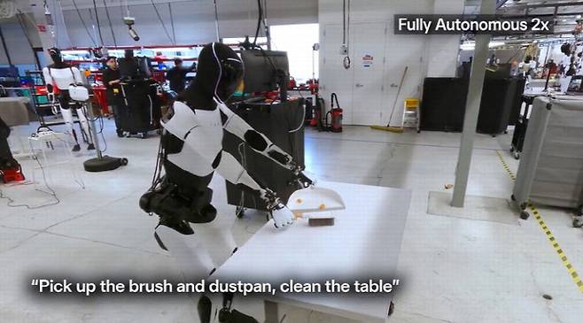 테슬라 옵티머스 로봇이 빗자루로 책상을 청소하는 모습. (사진=X캡처)