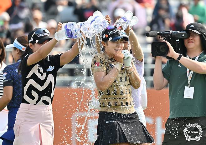 박현경이 25일 경기도 여주 페럼클럽에서 KLPGA 투어 E1 채리티 오픈 우승을 확정한 뒤 동료 선수들에게 축하 물 세례를 받고 있다./KLPGA