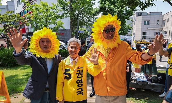 권영국 민주노동당 대통령 후보(가운데)가 25일 서울 마포구 연남동에서 거리 유세에 나서 사진을 찍고 있다. 왼쪽은 김세균 서울대 정치학과 명예교수, 오른쪽은 손호철 서강대 정치학과 명예교수로, 권 후보의 유세에 동행했다. 민주노동당 제공