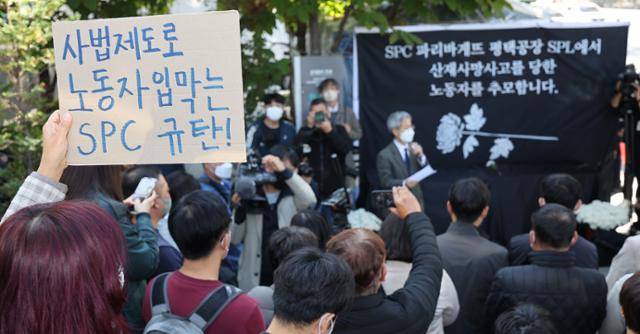 2022년 10월 20일 서울 양재동 SPC그룹 본사 앞에서 열린 SPC 계열사 SPL의 평택 제빵공장 사망 사고 희생자 서울 추모행사 도중 참가자가 회사 측을 규탄하는 문구를 적은 손팻말을 들고 있다. 연합뉴스