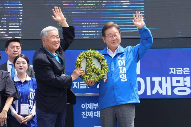 이재명(오른쪽) 더불어민주당 대선 후보가 22일 제주시 동문로터리 유세 중 제주 4·3사건 유족으로부터 꽃을 전달받고 있다. 제주=연합뉴스