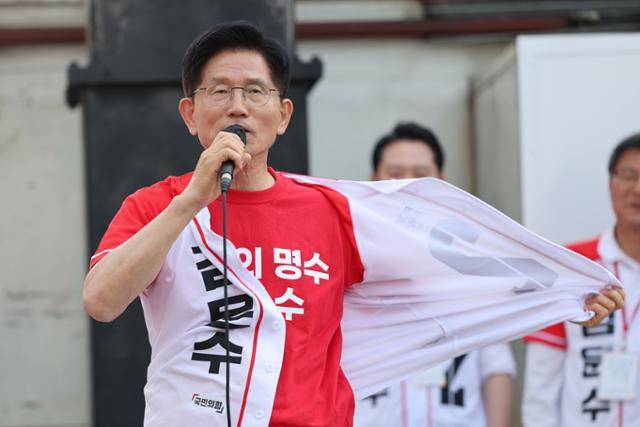 김문수 국민의힘 대선 후보가 25일 충남 서산시 중앙통 로데오거리에서 집중 유세를 하며 선거 운동복을 풀어헤치는 퍼포먼스를 하고 있다. 이재명 더불어민주당 대선 후보의 '방탄복, 방탄입법' 논란을 비판하기 위한 목적이다. 서산=공동취재사진