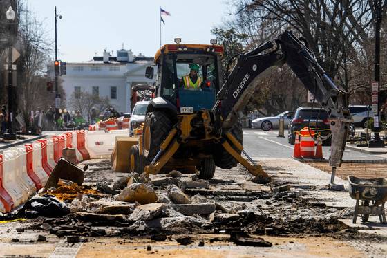 2025년 3월 12일, 백악관을 배경으로 한 굴착기가 워싱턴 DC의 흑인의 생명도 소중하다는 광장에 포크레인으로 철거 작업을 하고 있다. AP=연합뉴스
