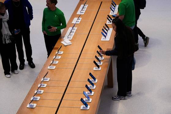 People browse iPhones at the Apple Fifth Avenue store, in New York City, on May 23, 2025. [REUTERS/YONHAP]