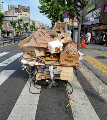 끄는 사람이 보이지 않을 정도로 높이 쌓인 폐지 리어카./사진=녹색병원 제공