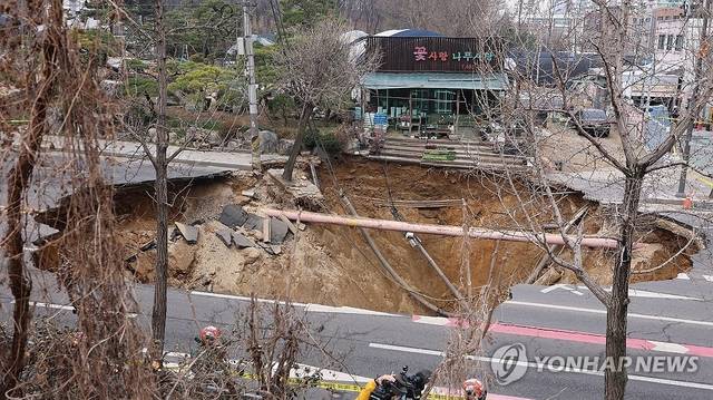 지난 3월24일 서울 강동구 명일동 대명초등학교 인근 사거리에서 발생한 지름 20ｍ, 깊이 18ｍ가량의 대형 싱크홀(땅꺼짐) 현장 모습. 연합뉴스