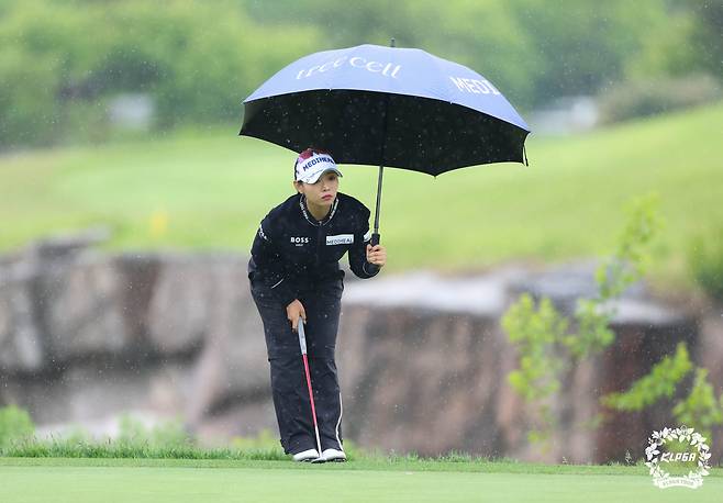 우산을 들고 18번 홀 그린에서 퍼팅 라인을 살피고 있는 이채은2. [사진=KLPGA]