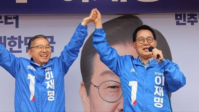 24일 순천 조례호수공원 유세에서 박지원 의원(우측)이 김문수 의원 손을 잡고 민주당 대선후보 이재명 지지를 호소하고 있다. [사진 민주당]