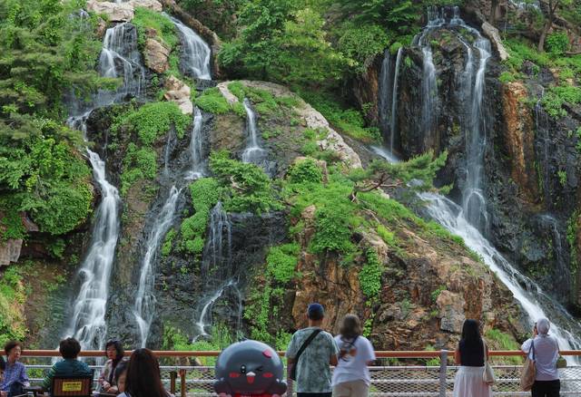 서울 서대문구 홍제폭포를 찾은 시민과 관광객들이 그늘에서 폭포 풍경을 즐기고 있다. 연합뉴스