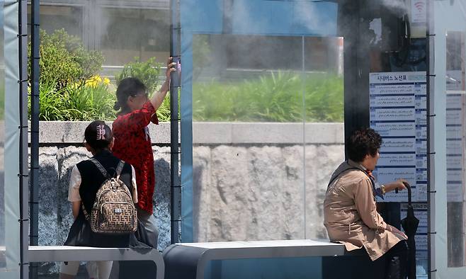 30도가 넘는 무더위가 나타난 지난 20일 강원도 강릉의 한 시내버스 정류장에&nbsp;‘쿨링포그’(안개분사장치)가 가동되고 있다. 연합뉴스