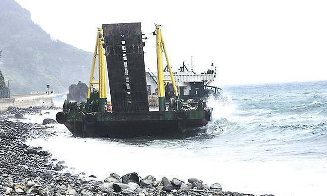 지난 24일 오후 2시30분쯤 울릉공항 공사 현장 앞바다에 정박 중인 바지선이 좌초돼 예인선이 선박을 예인하고 있다.&nbsp;