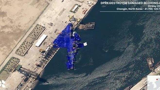 진수식에서 파손된 북한 신형 5000t급 구축함. 함수는 육지에, 함미는 물에 있는 채로 파란색 방수포가 둘러져 있는 것으로 보인다. /영국 비영리 안보연구기관 오픈소스센터(OSC) 엑스(X) 캡처