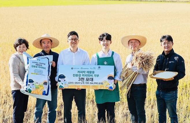 스타벅스 임직원들이 경기 평택시의 한 가루쌀 농가를 방문해 커피찌꺼기 퇴비를 전달하며 기념촬영을 하고 있다. 스타벅스 코리아 제공