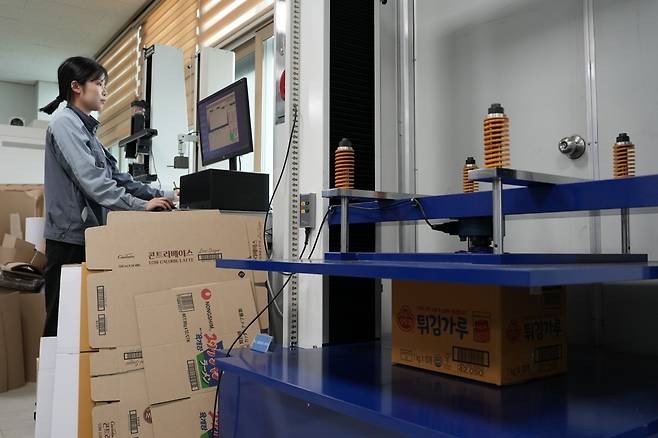 태림포장 시화공장 내에 있는 태림 기술연구소에서 한 연구원이 골판지 상자 압축강도를 측정하고 있다. 태림포장 제공