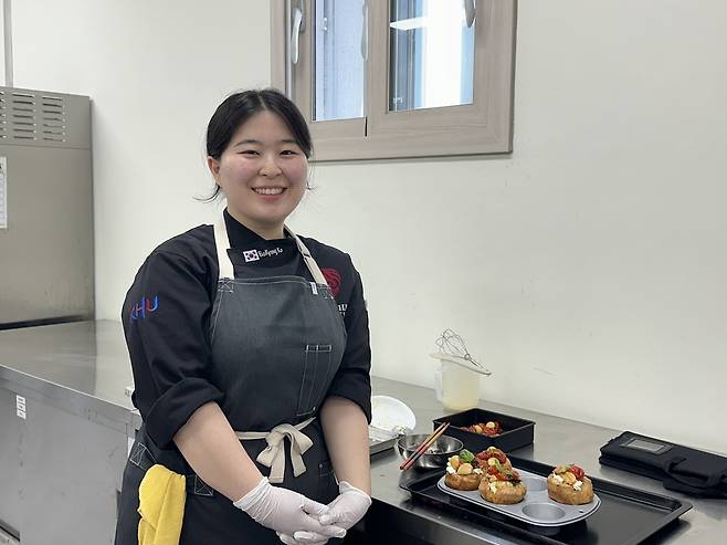 Ko Bo-kyung, a 21-year-old student in the Department of Culinary Science and Foodservice Management at Kyung Hee University, poses with Yorkshire puddings she developed using Daejeong-eup's specialty products on May 13, at a cafe in Seogwipo, Jeju Island. (Choi Jeong-yoon/The Korea Herald)