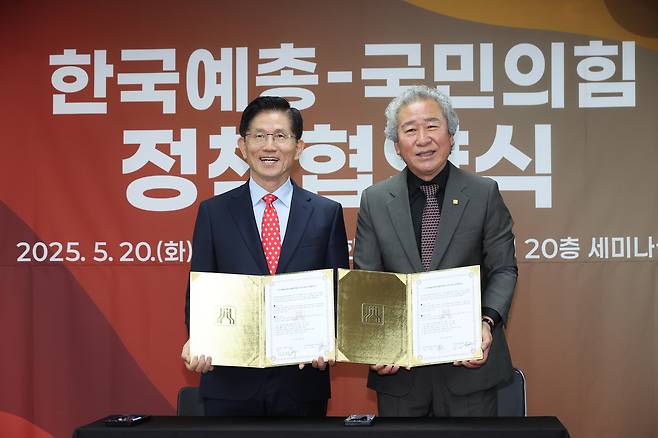 People Power Party presidential candidate Kim Moon-soo (left) poses for a photo with Cho Kang-hoon, president of the Federation of Artistic and Cultural Organizations of Korea, during a policy agreement ceremony with the People Power Party, held at the Korea Artists Center in Yangcheon-gu, Seoul, on May 20.  (Yonhap)